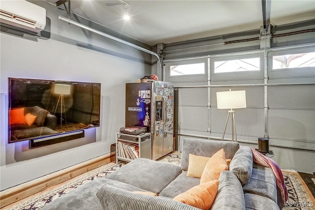 garage featuring an AC wall unit and stainless steel fridge with ice dispenser