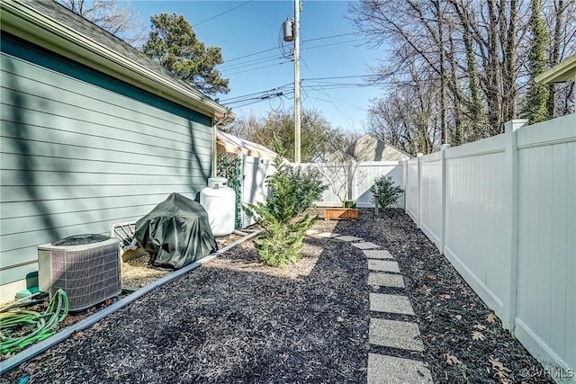 view of yard with central AC and a fenced backyard