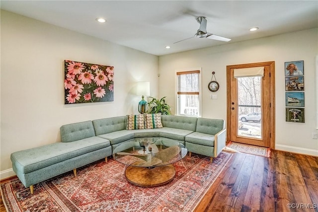 living room featuring hardwood / wood-style flooring, baseboards, a ceiling fan, and recessed lighting