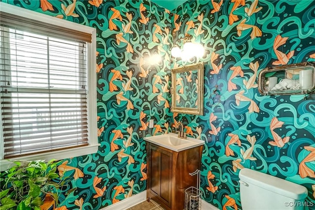 half bath featuring a healthy amount of sunlight, wallpapered walls, and toilet