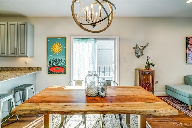 dining area with an inviting chandelier, baseboards, and wood finished floors