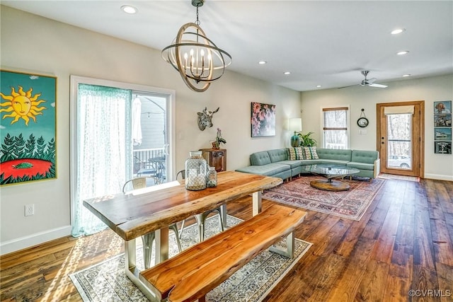 dining room with baseboards, hardwood / wood-style floors, ceiling fan with notable chandelier, and recessed lighting