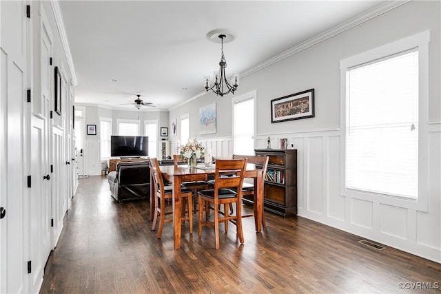 dining area featuring ornamental molding, dark wood-style flooring, visible vents, and a decorative wall