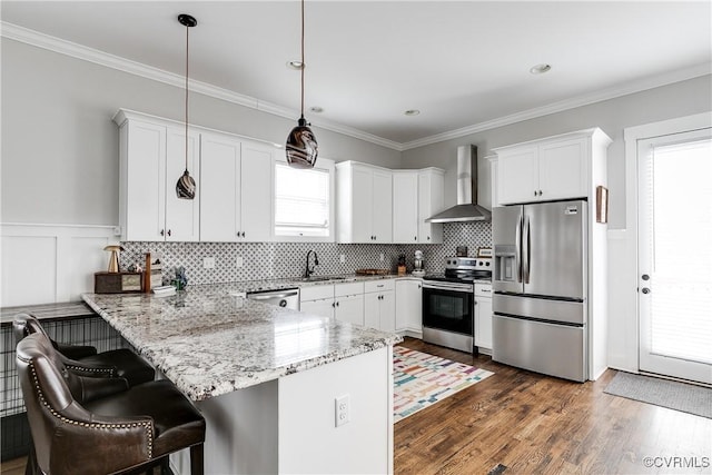 kitchen featuring stainless steel appliances, white cabinetry, a peninsula, and wall chimney exhaust hood