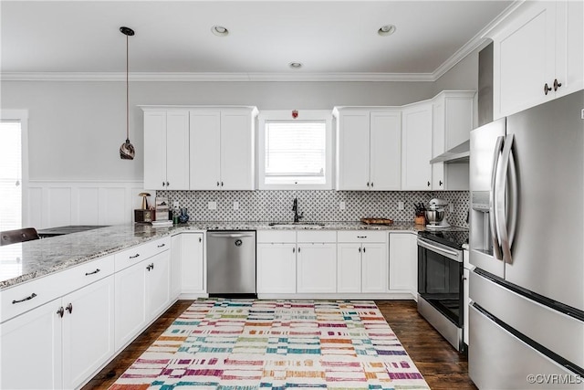 kitchen with appliances with stainless steel finishes, white cabinets, crown molding, and a sink