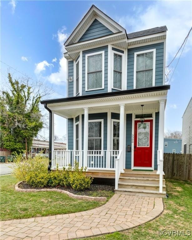 view of front facade with covered porch and fence