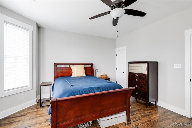 bedroom featuring wood finished floors, a ceiling fan, and baseboards