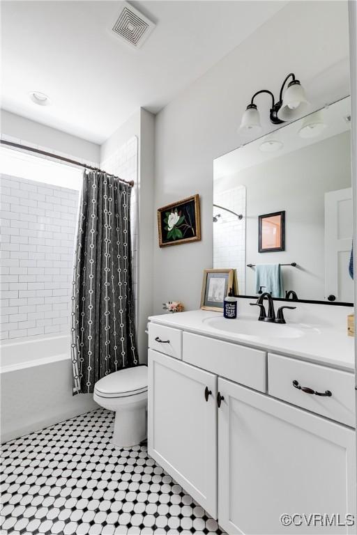 bathroom featuring visible vents, shower / tub combo with curtain, vanity, and toilet