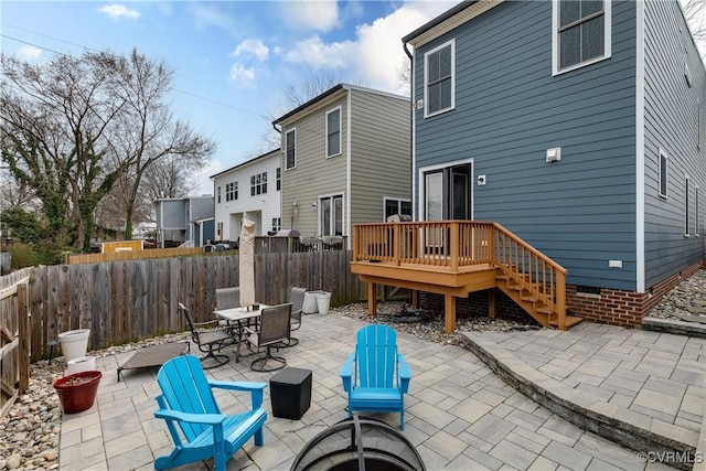 rear view of house featuring a patio, outdoor dining space, a fenced backyard, and a wooden deck