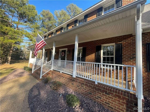 view of front facade featuring covered porch and brick siding