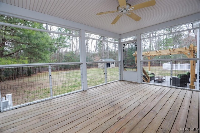 unfurnished sunroom featuring a ceiling fan and a wealth of natural light