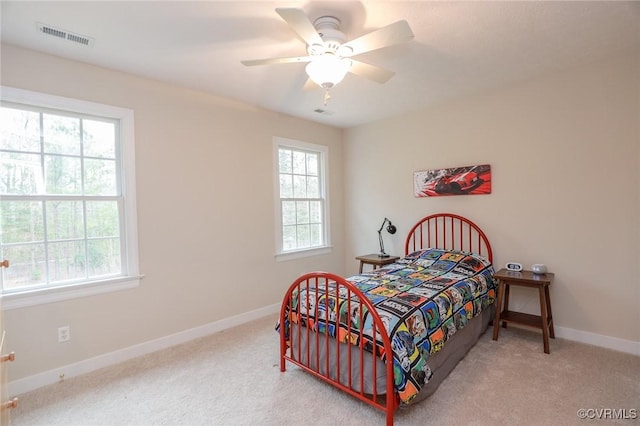 carpeted bedroom with a ceiling fan, visible vents, baseboards, and multiple windows