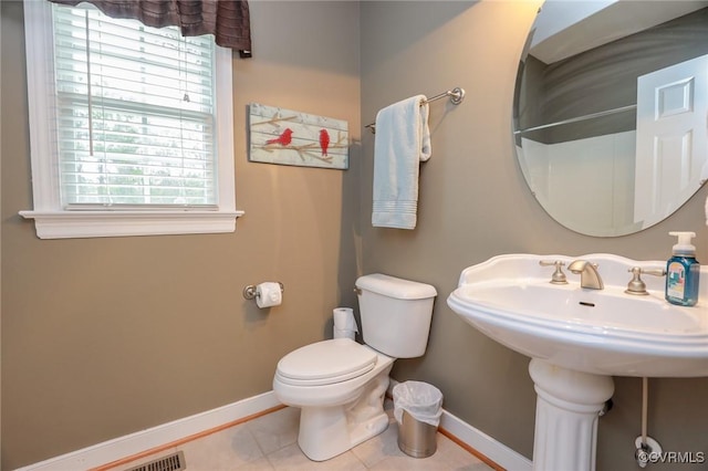 bathroom with tile patterned flooring, toilet, and baseboards