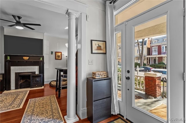 entryway featuring a wealth of natural light, ceiling fan, ornate columns, and wood finished floors