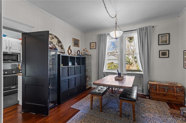 dining space featuring crown molding and dark wood-style flooring