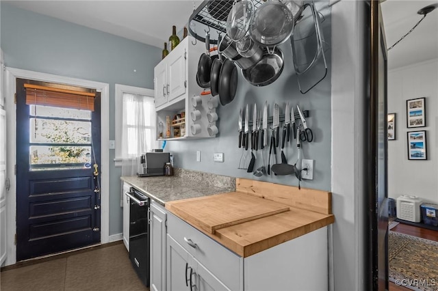 kitchen featuring butcher block countertops, stainless steel microwave, white cabinetry, and open shelves