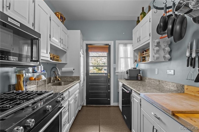 kitchen with stainless steel gas range oven, a sink, white cabinets, and open shelves