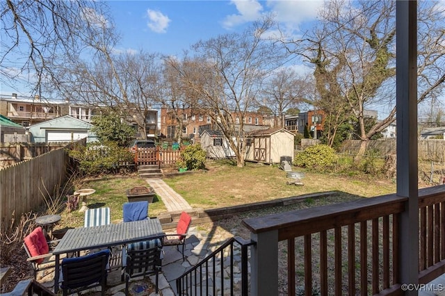 view of yard with an outbuilding, a fenced backyard, a residential view, and a wooden deck