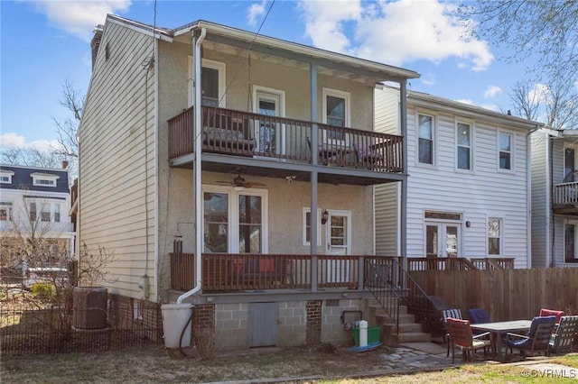 rear view of house with fence, central air condition unit, stucco siding, covered porch, and a balcony