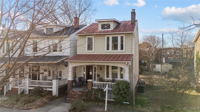 traditional style home featuring covered porch and a chimney