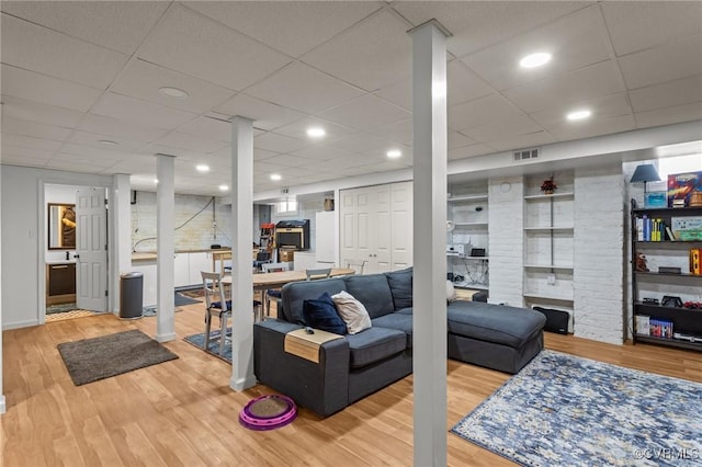 living room with recessed lighting, wood finished floors, and visible vents