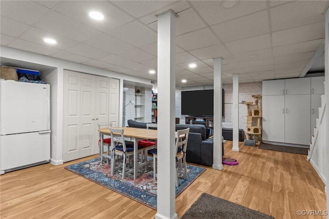 dining room with a drop ceiling, recessed lighting, and light wood finished floors