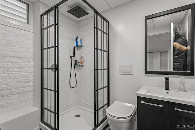 bathroom featuring vanity, a shower stall, and toilet