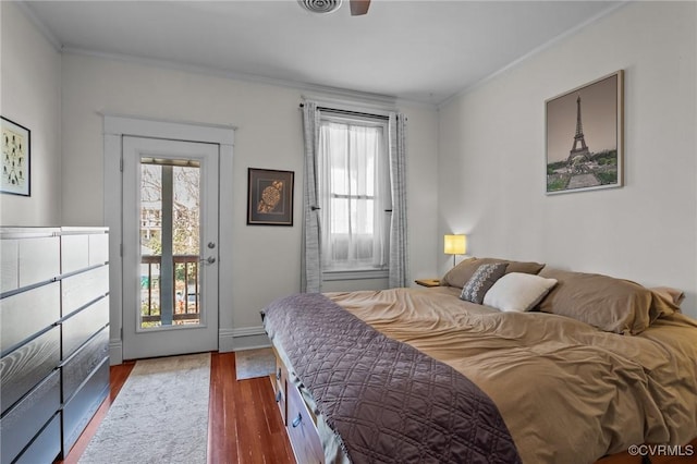 bedroom featuring access to exterior, crown molding, and wood finished floors