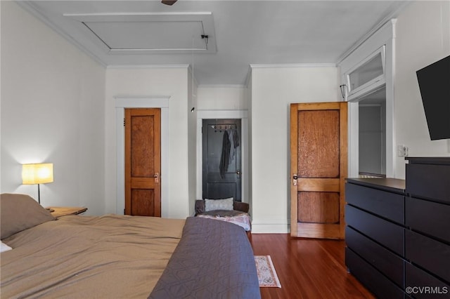 bedroom with dark wood finished floors, attic access, a closet, and ornamental molding