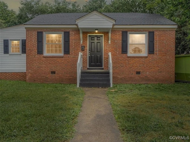 view of front of home with brick siding, a shingled roof, entry steps, crawl space, and a front lawn