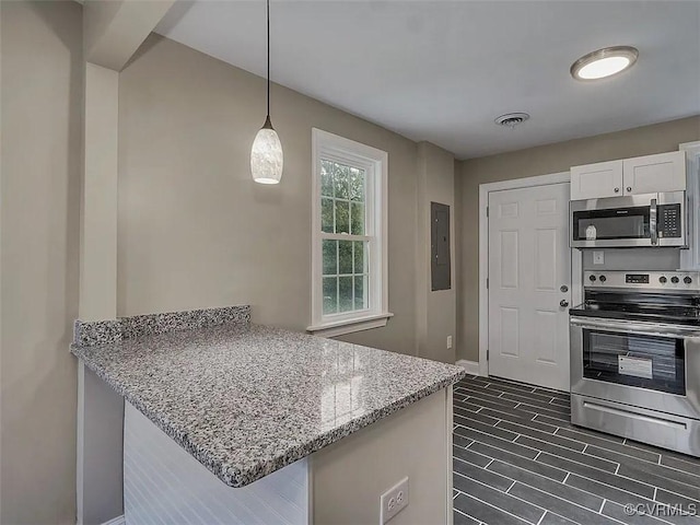 kitchen featuring visible vents, a peninsula, light stone countertops, stainless steel appliances, and white cabinetry