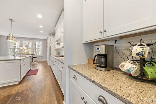 kitchen featuring dark wood finished floors, stainless steel gas cooktop, recessed lighting, white cabinetry, and a sink