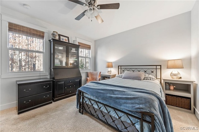 bedroom featuring multiple windows, light carpet, and baseboards