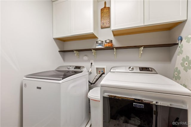 washroom with cabinet space and washing machine and dryer