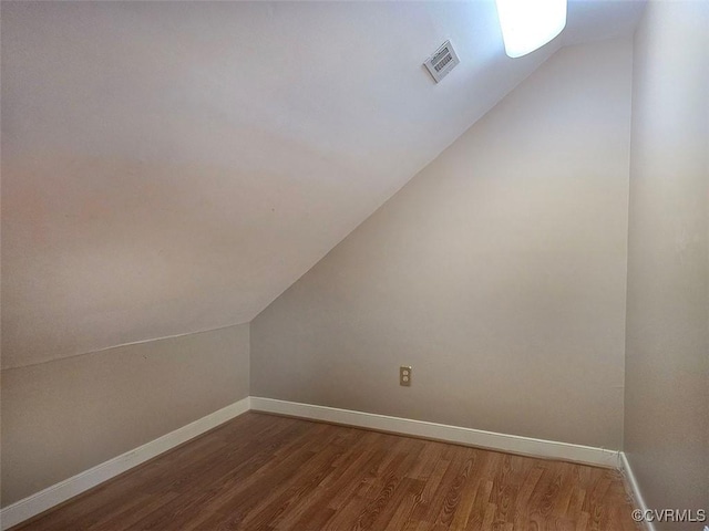 bonus room with wood finished floors, visible vents, and baseboards