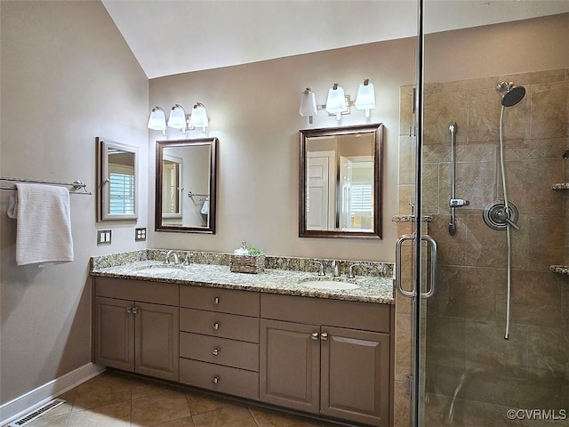 bathroom with a stall shower, visible vents, and a sink