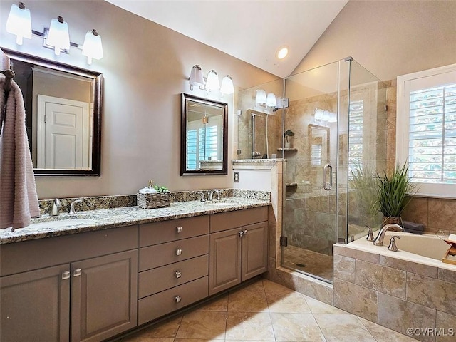 bathroom featuring a sink, vaulted ceiling, a shower stall, a bath, and double vanity