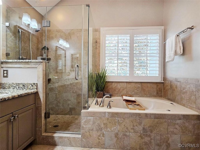 bathroom featuring a shower stall, a bath, and vanity