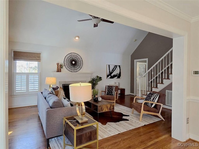 living room featuring a fireplace, stairway, vaulted ceiling, and wood finished floors