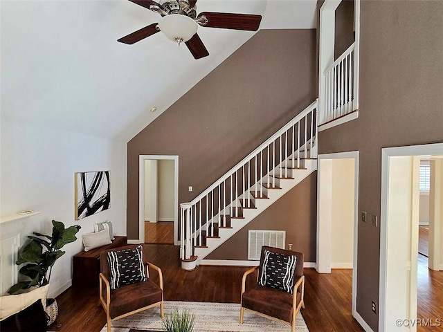 interior space with visible vents, stairway, wood finished floors, high vaulted ceiling, and baseboards