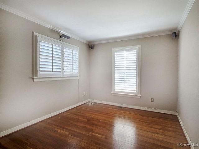 empty room with baseboards, wood finished floors, and ornamental molding