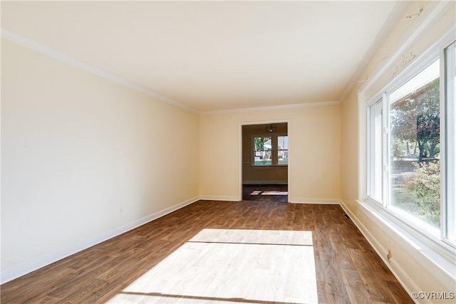 unfurnished room featuring ornamental molding, baseboards, and wood finished floors