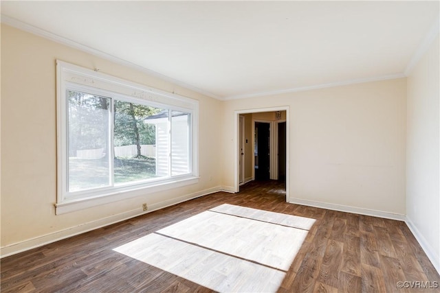 empty room with crown molding, baseboards, and wood finished floors