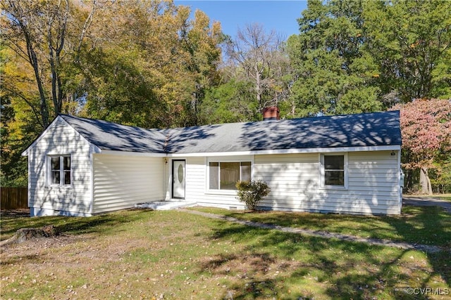 ranch-style house with a chimney and a front yard