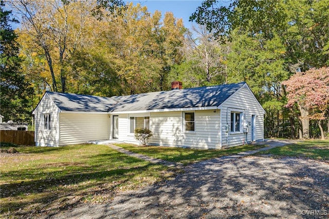 ranch-style house featuring a front yard and fence