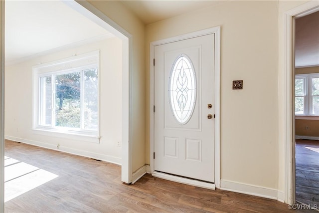 entrance foyer featuring baseboards, visible vents, and wood finished floors