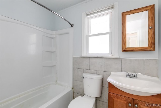 full bath featuring shower / tub combination, toilet, vanity, tile walls, and wainscoting