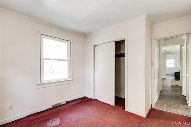 unfurnished bedroom with attic access, baseboards, visible vents, ornamental molding, and a closet