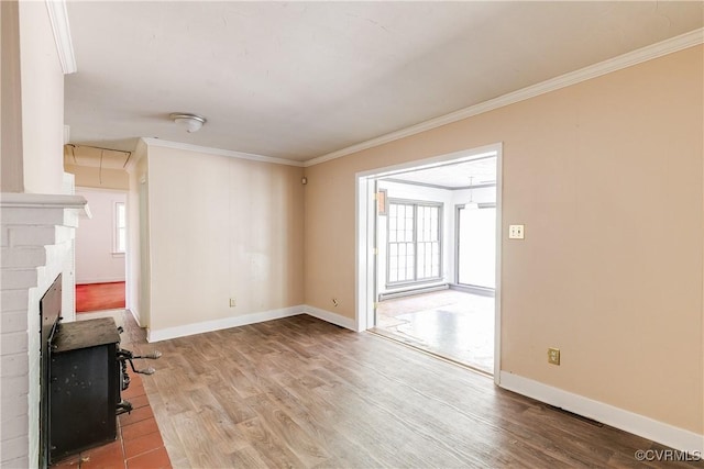 living area with baseboards, wood finished floors, attic access, and crown molding