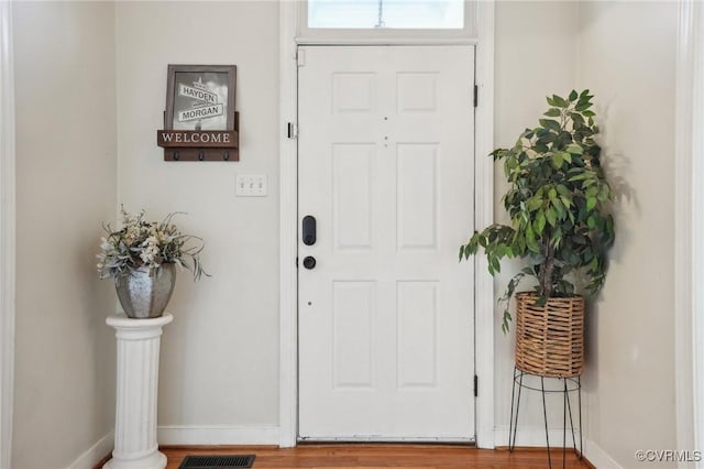 foyer with visible vents, baseboards, and wood finished floors